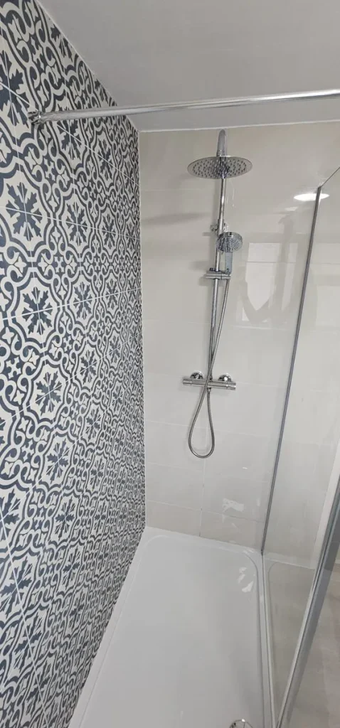Chrome thermostatic rainfall shower against patterned blue tiles