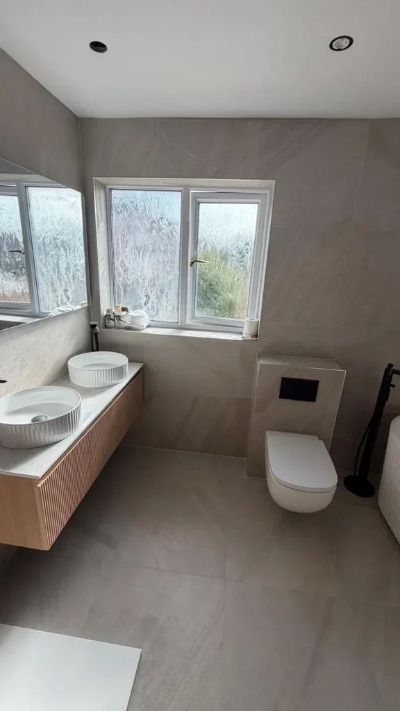 Double vessel basins on a fluted oak vanity with wall-hung WC