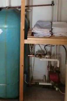 Hot water cylinder and pump in an airing cupboard